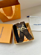 Dark monogram leather belt resting in box with silver-toned LV buckle.