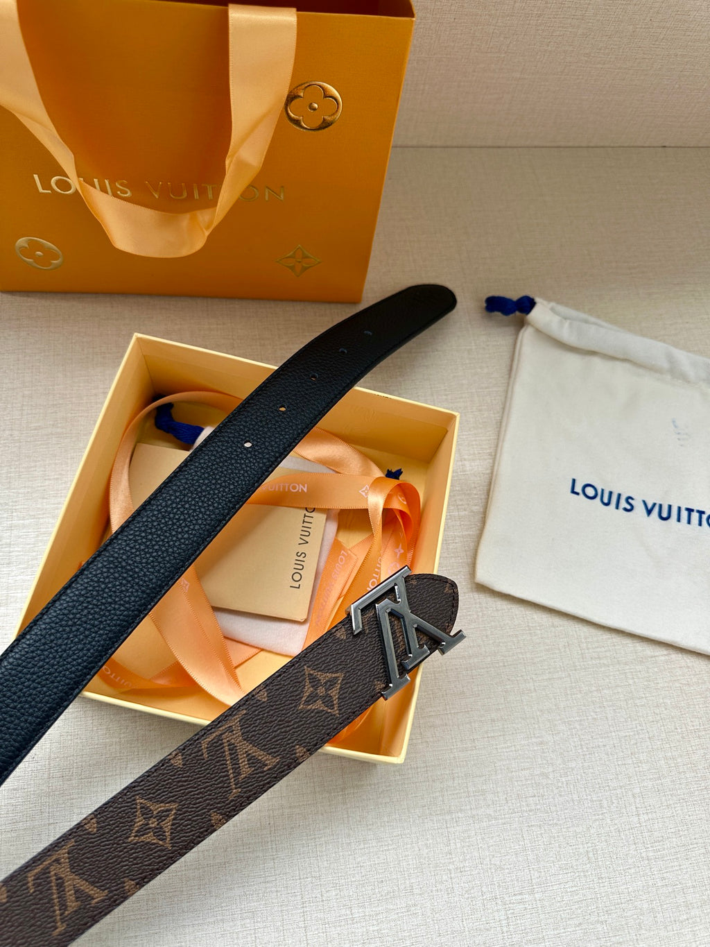 Dark monogram leather belt with silver-toned LV buckle in gift box.