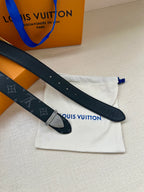 Monogram leather belt with dark strap and gold-tone clasp buckle, laid flat