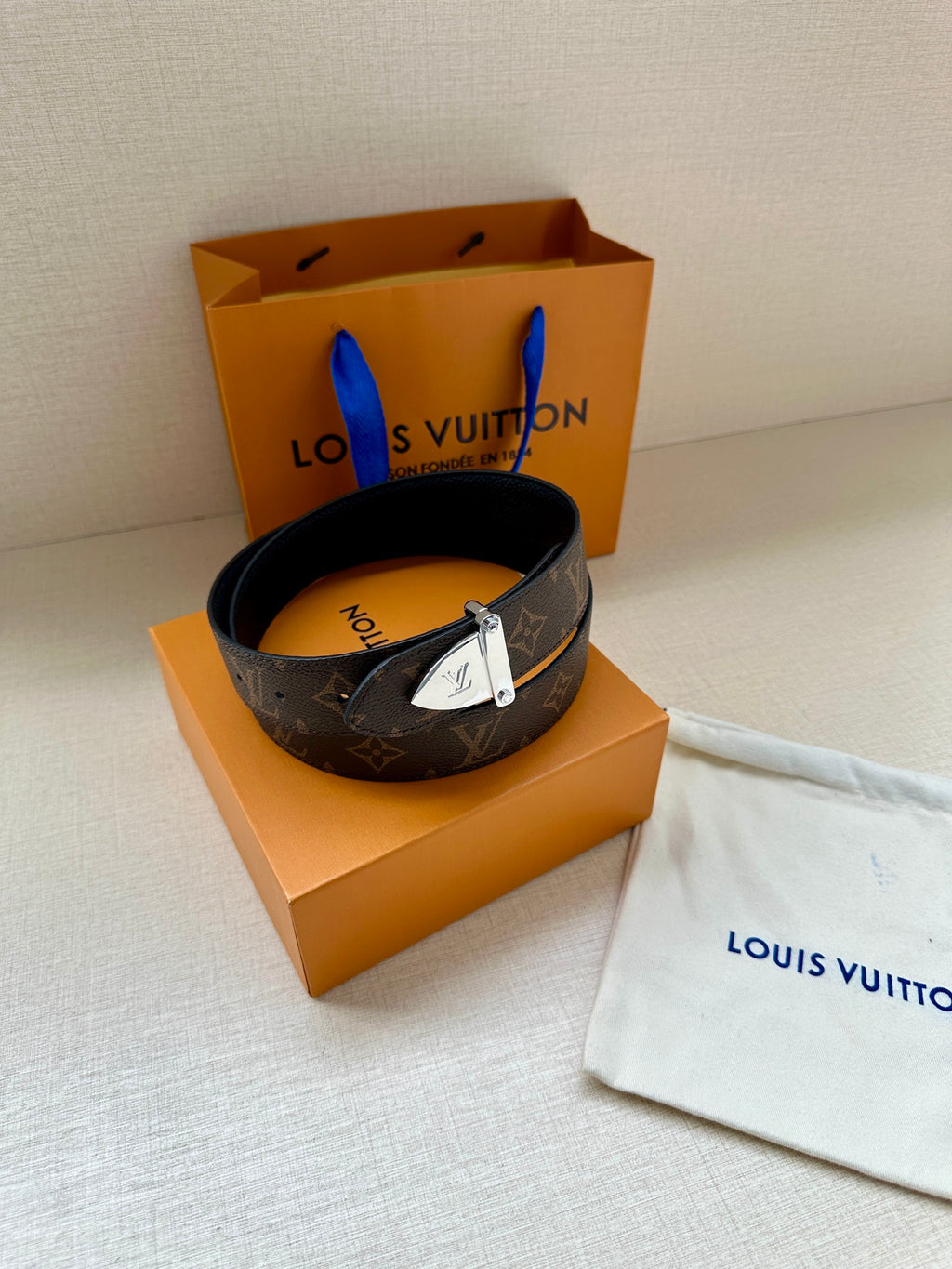 Louis Vuitton monogram belt coiled with silver buckle and dark strap