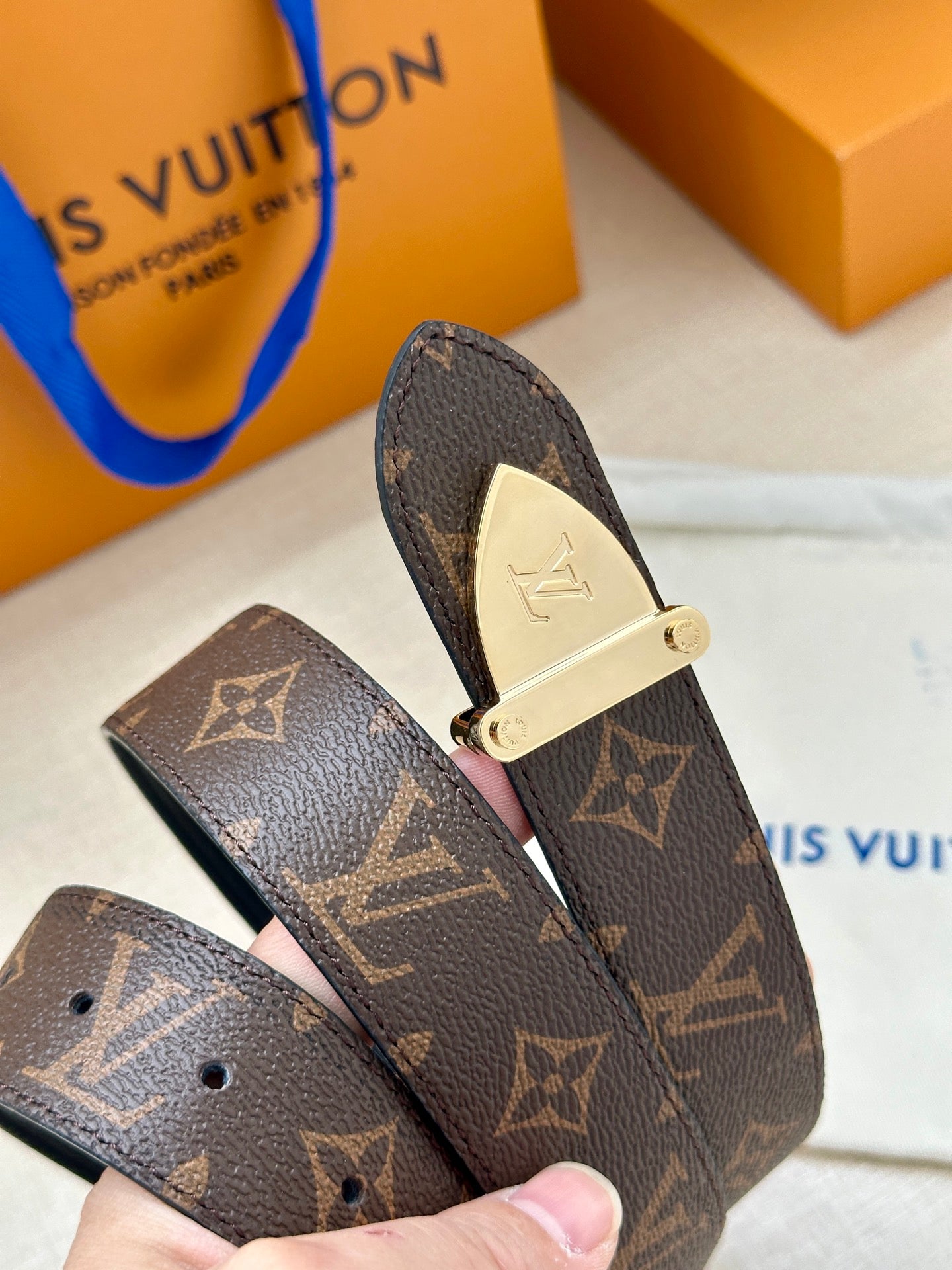 Louis Vuitton belt buckle close-up on dark brown monogram strap