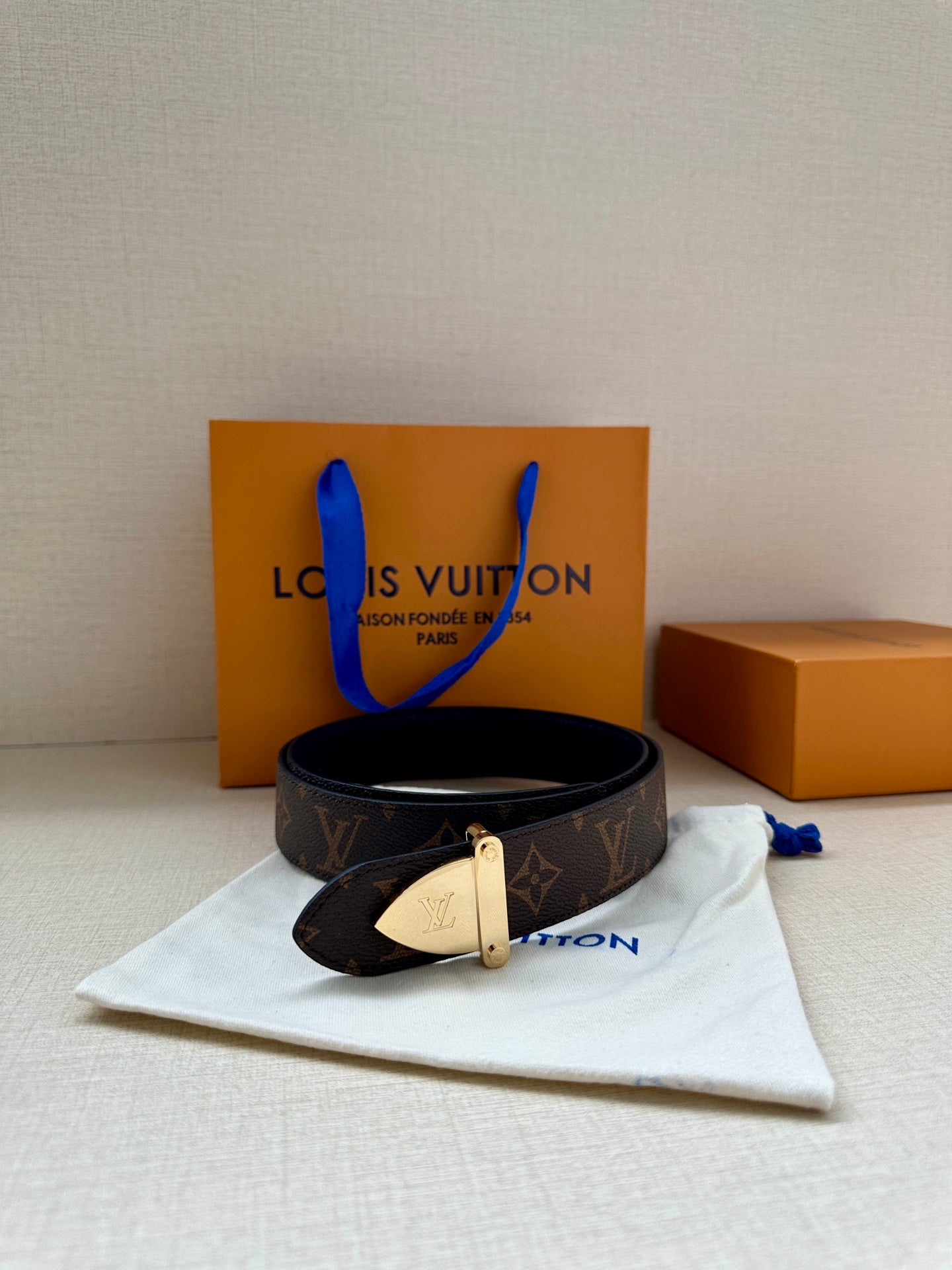 Louis Vuitton belt with dark brown monogram strap and light gold-tone buckle