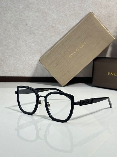 Eyeglasses with black frame and gold-toned temples, clear lenses, front side view