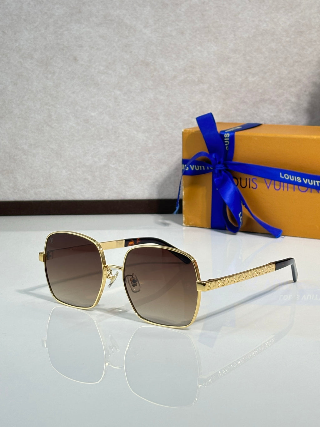 Gold-tone round-edged sunglasses with brown lenses and textured temple arms