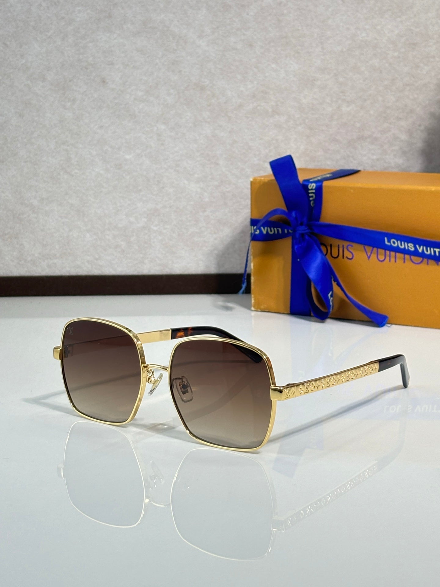 Gold-tone round-edged sunglasses with brown lenses and textured temple arms