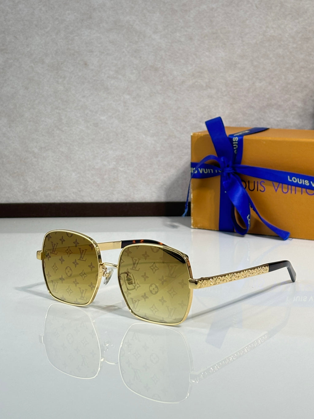 Gold-tone square sunglasses with beige logo print lenses and textured temple arms