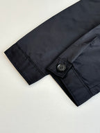Long jacket sleeve cuff with buttoned tab, dark fabric