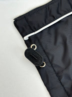Prada black jacket pocket detail with snap closure and black logo keychain tag