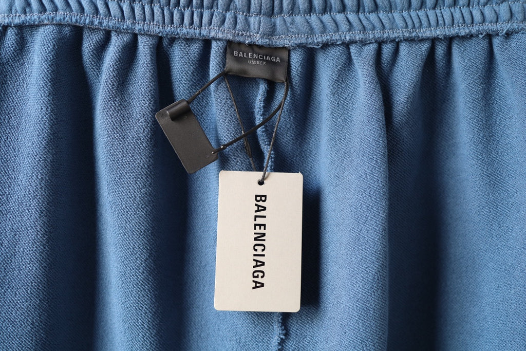 Blue pants waistband with Balenciaga label tag hanging from center
