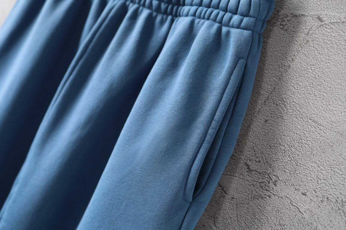 Blue pants with gathered elastic waist and draped front pleats