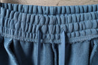 Blue elastic waistband with gathered fabric and vertical seam details