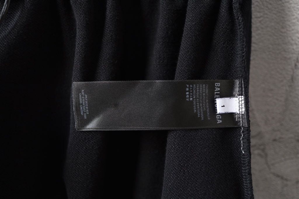 Balenciaga black pants with brand tag label attached near hem