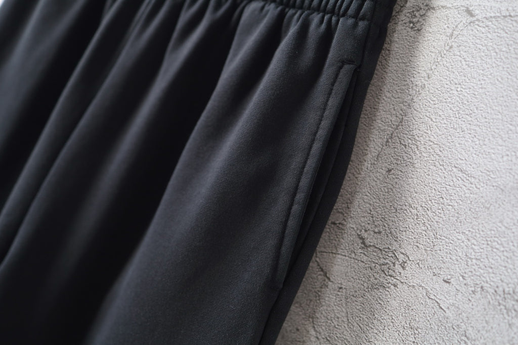 Balenciaga black wide-leg pants with smooth drape and soft folds
