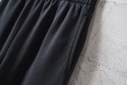 Balenciaga black wide-leg pants with smooth drape and soft folds
