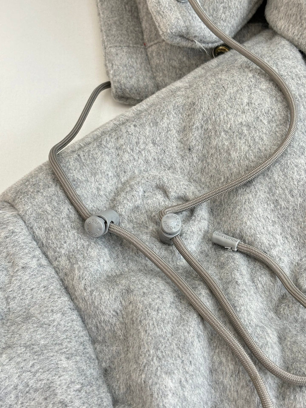 Light gray Louis Vuitton monogram jacket with adjustable hood cords and drawstring
