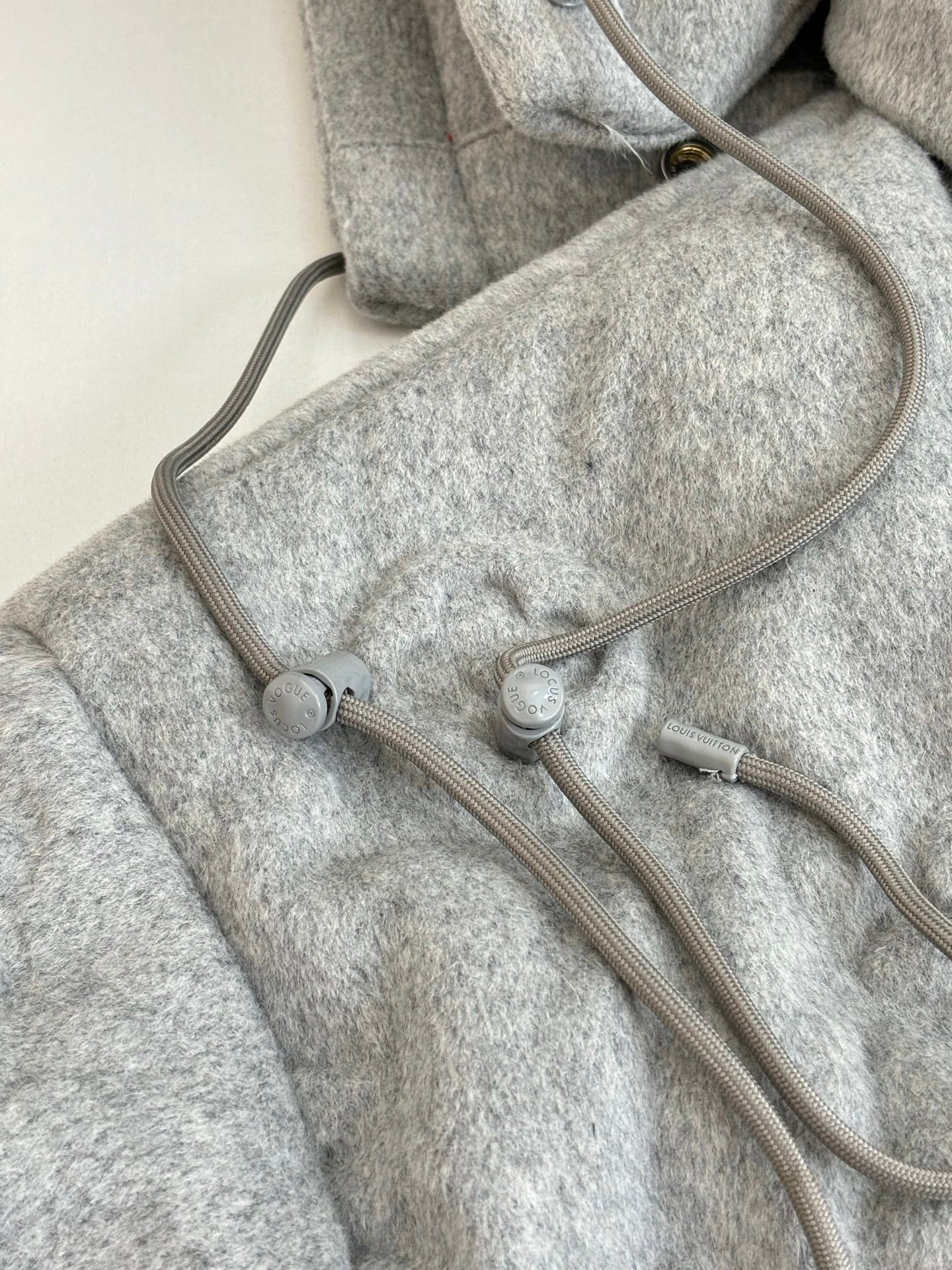 Light gray Louis Vuitton monogram jacket with adjustable hood cords and drawstring
