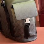 Side detail of monogram mini backpack with front flap, clasp, and black strap