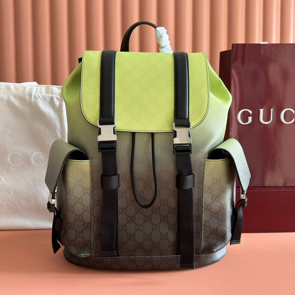 Green mini backpack with black top handles, front flap, and monogram canvas sides