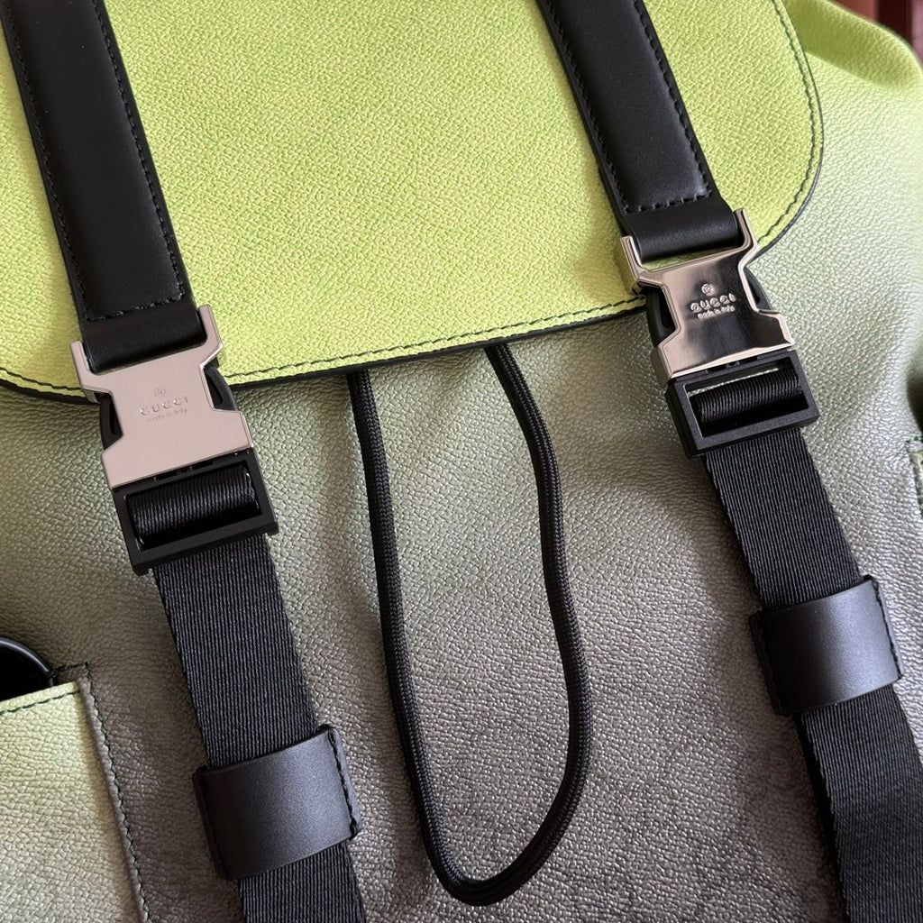 Detail of green flap with black buckles, webbing straps, and metal connectors