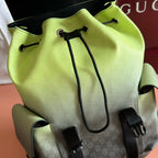 Green mini backpack with drawstring cords, black caps, and side release strap