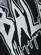 Dark hoodie close-up of white graffiti-style lettering print.