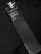 Dark hoodie fabric with inner neck label and care text.