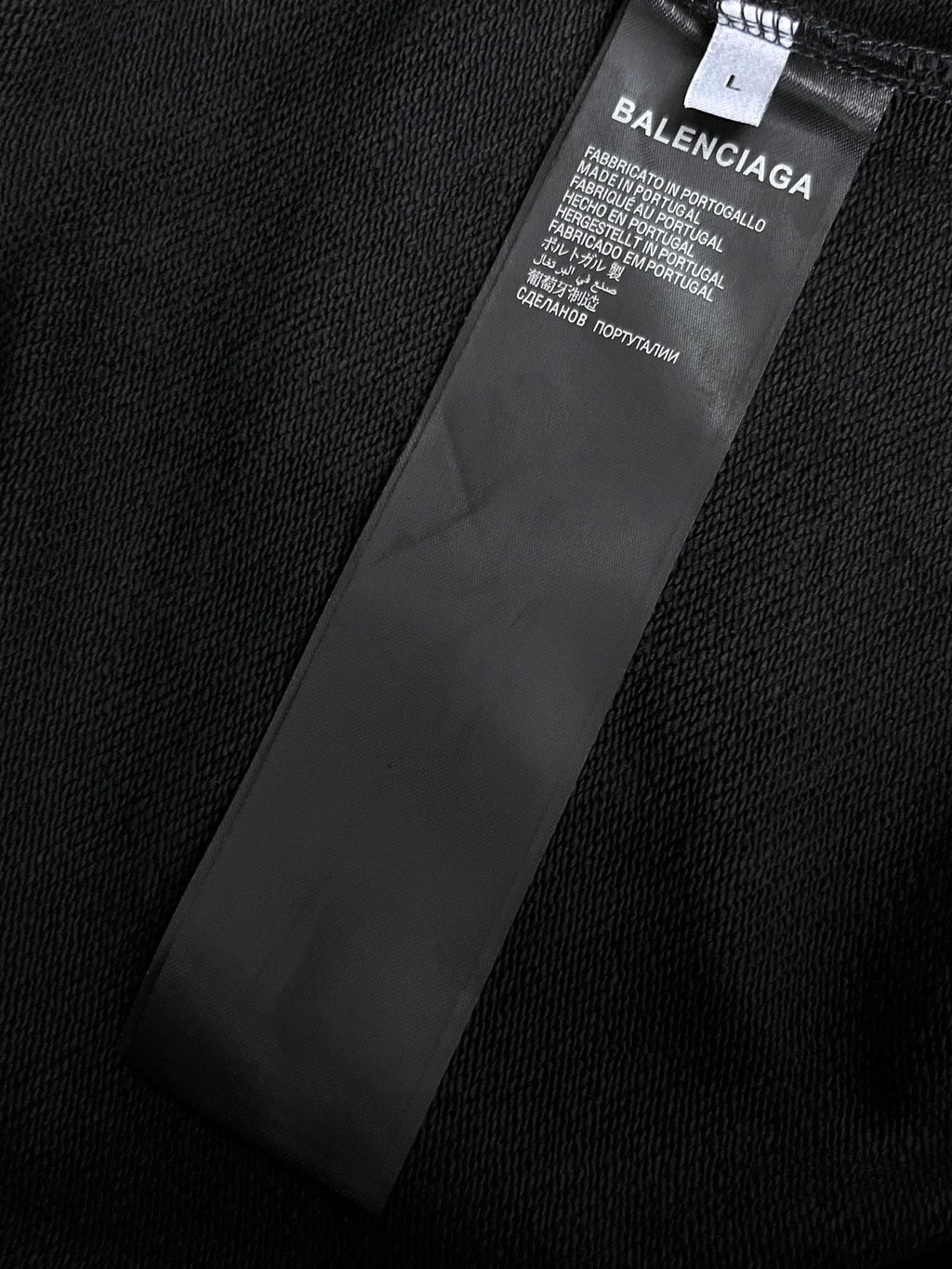 Balenciaga garment label on dark hoodie fabric near inner seam