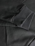 Dark hoodie fabric close-up with layered hood seam and stitching