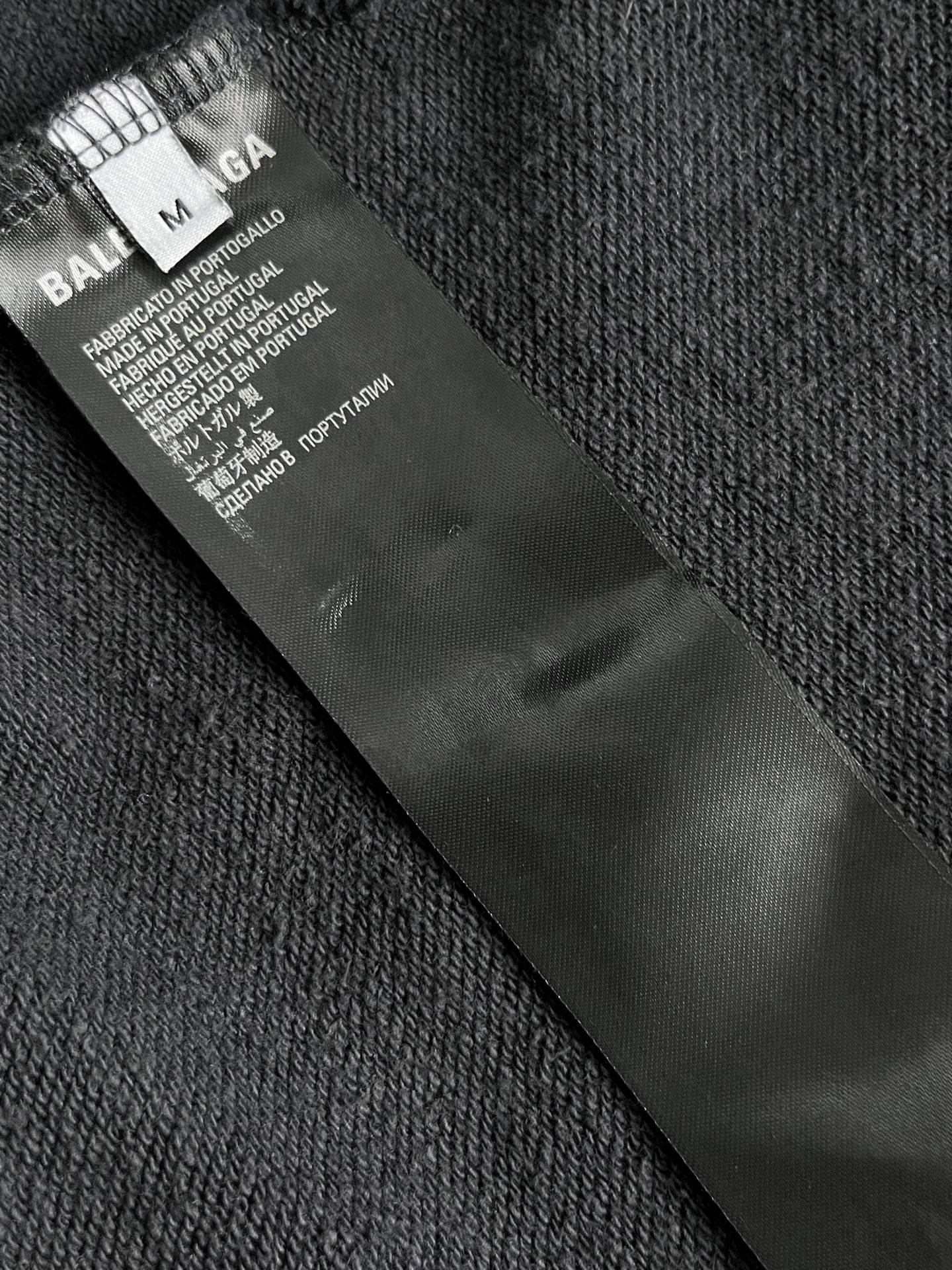 Dark navy hoodie care label and size tag inside collar
