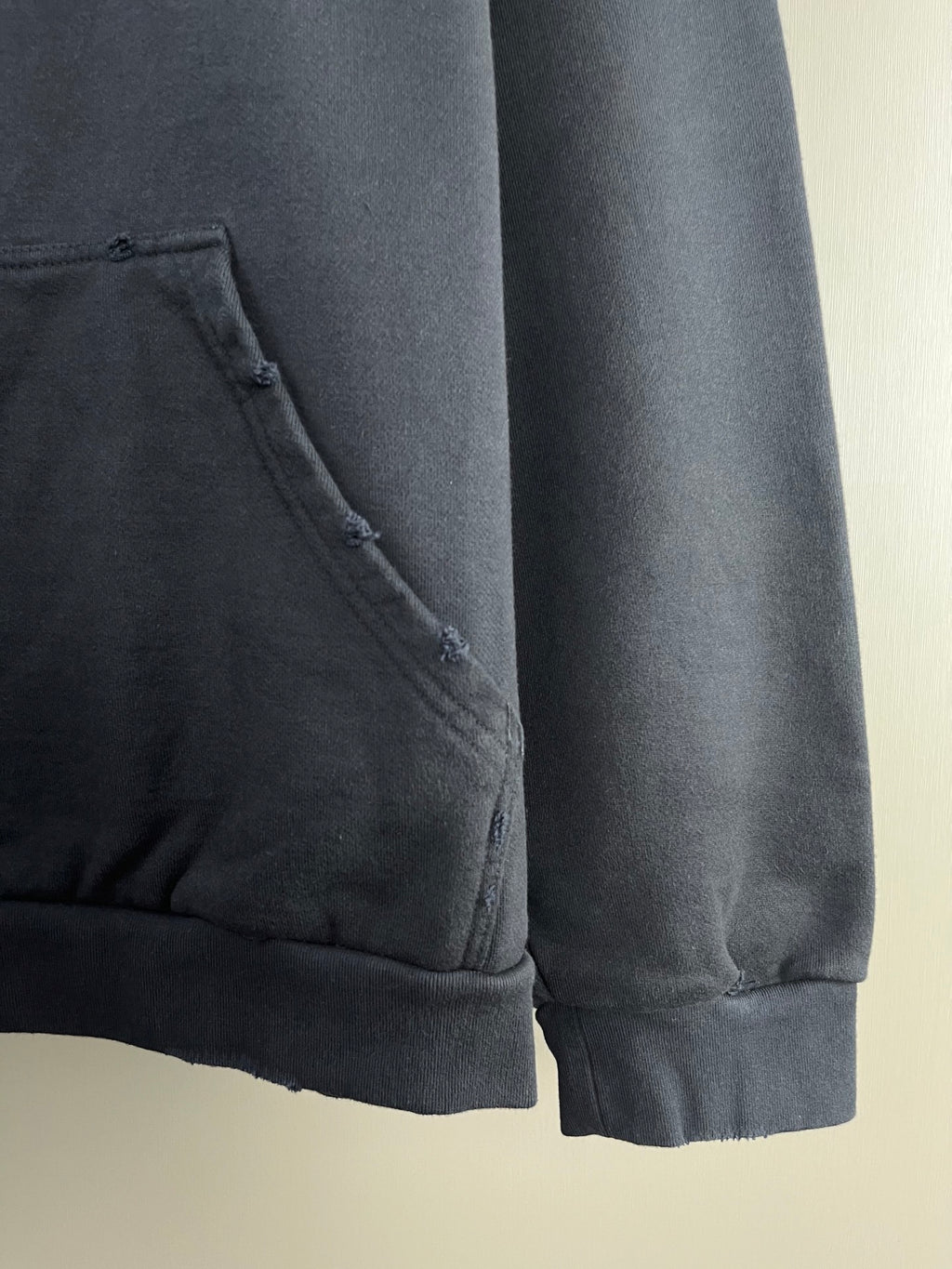 Dark navy hoodie sleeve hem with stitched pocket edge and cuff