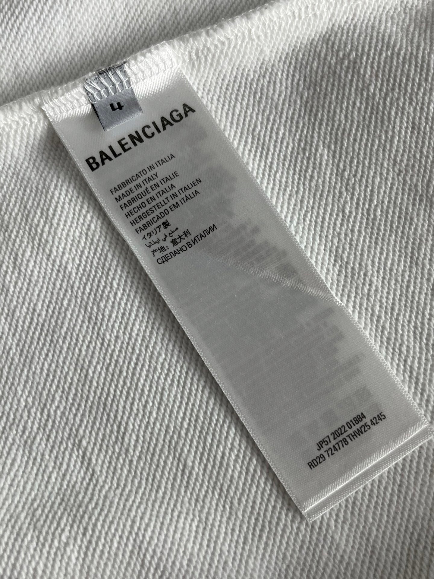 White sweatshirt care label tag with Balenciaga branding and size info