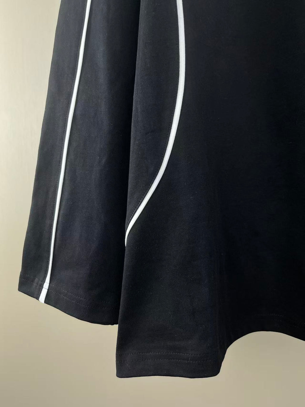 Black jersey side stripe with white piping along the sleeve