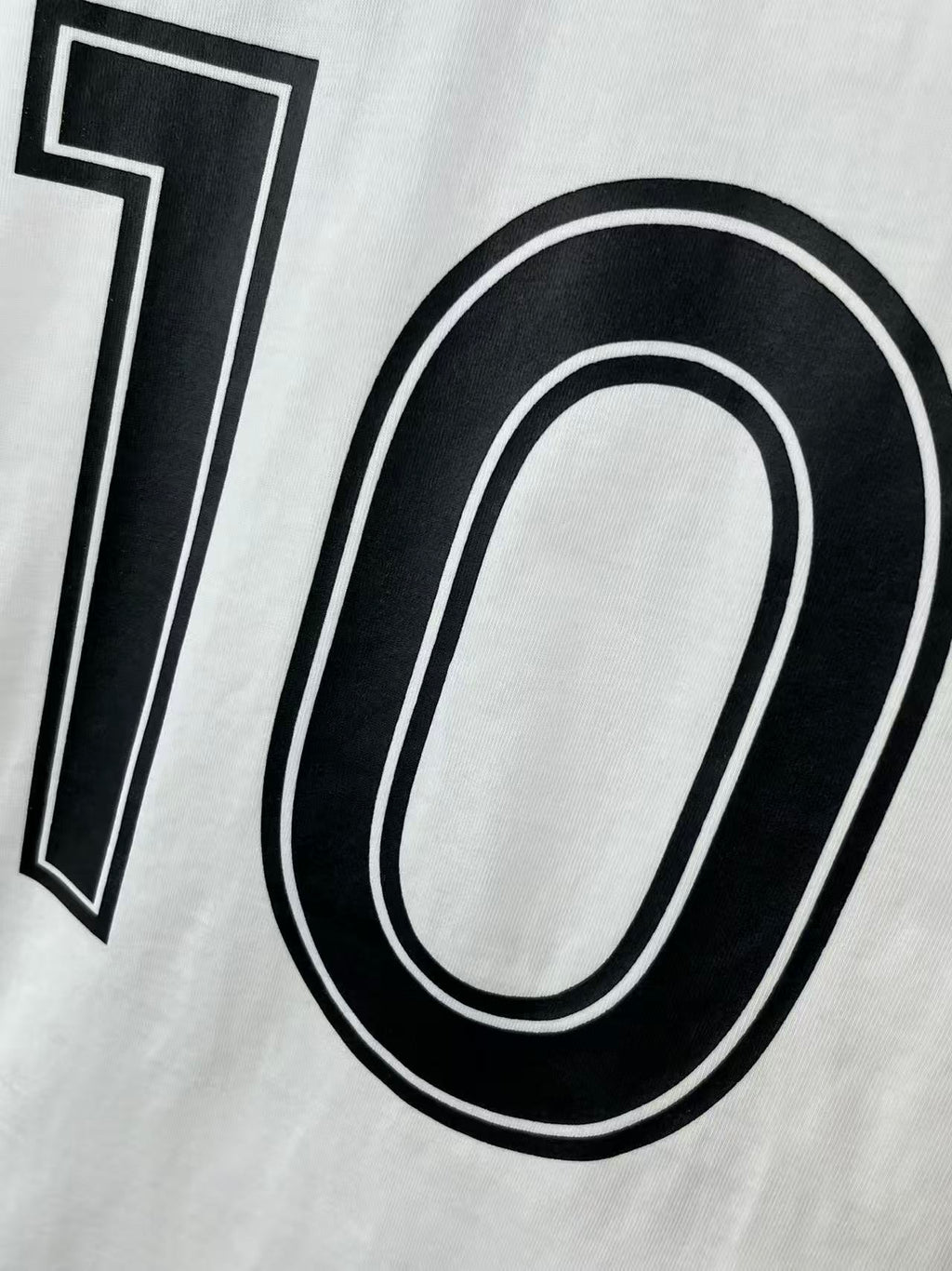 White jersey detail with black 10 graphic and double-line outline