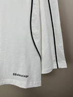 White jersey with short side slit, vertical black stripe, and small Balenciaga text