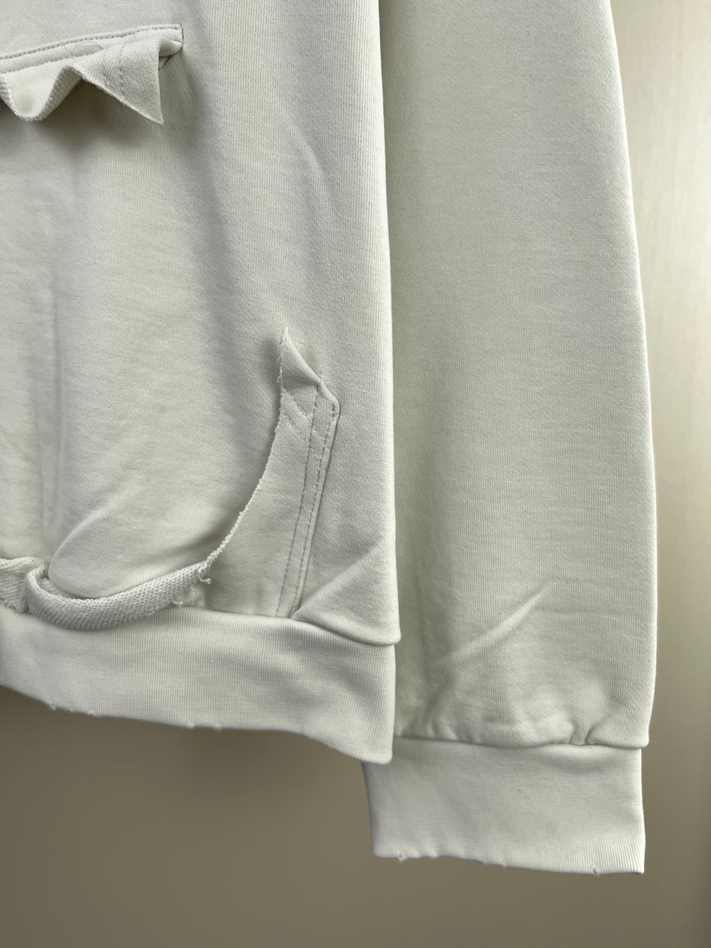 White hoodie sleeve with ribbed cuff and pocket seam detail