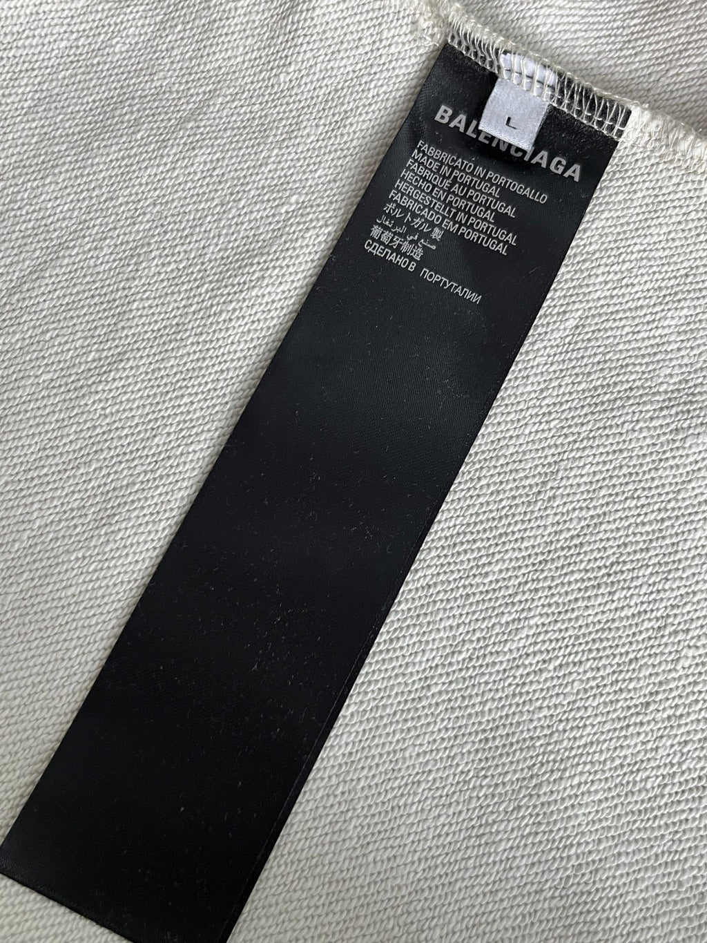 Black size label inside white hoodie with 'BALENCIAGA' text