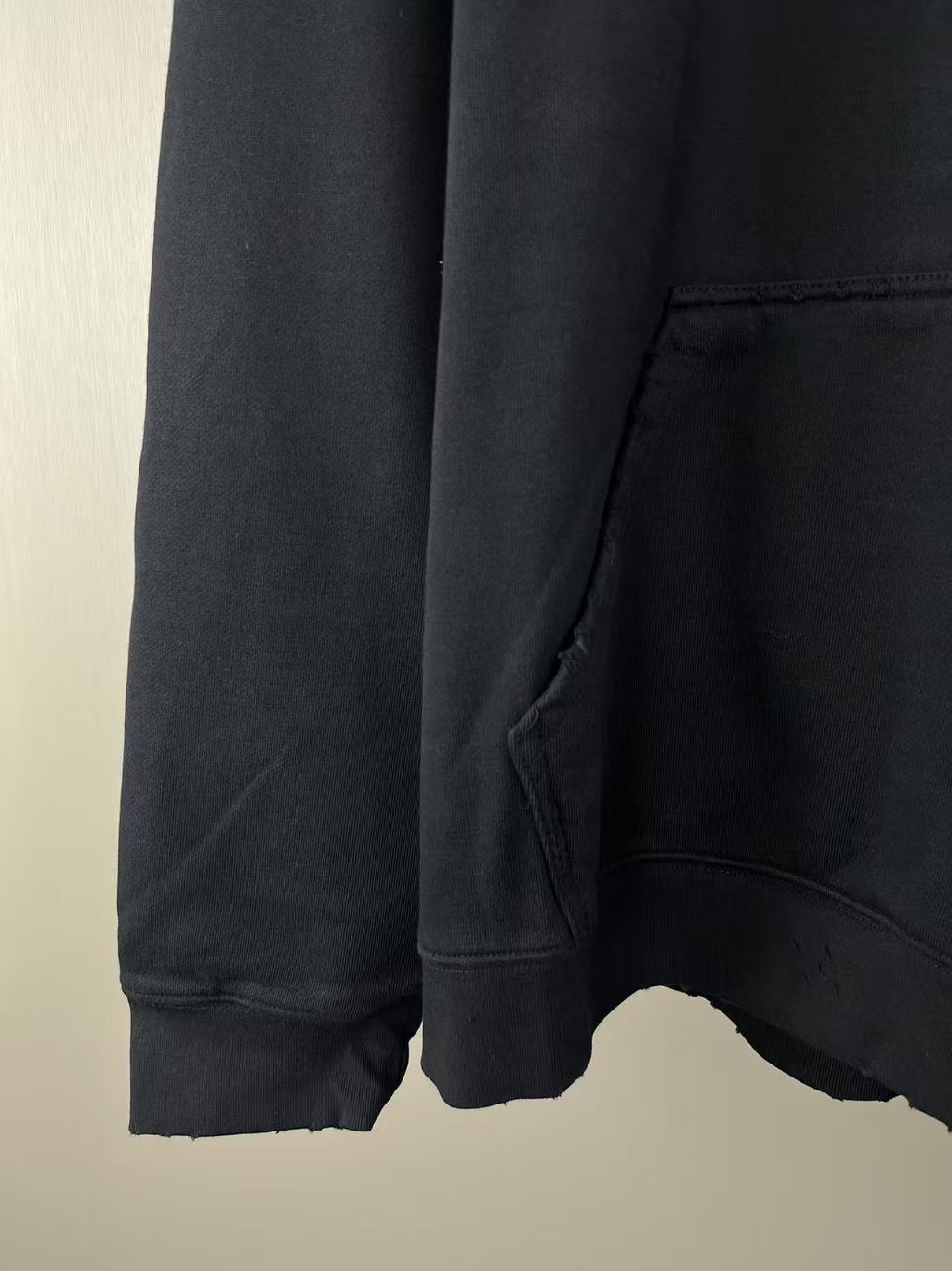 Long hoodie sleeve and hem with curved cutout and visible stitching