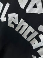 Close-up of angled white graphic lettering on dark hoodie