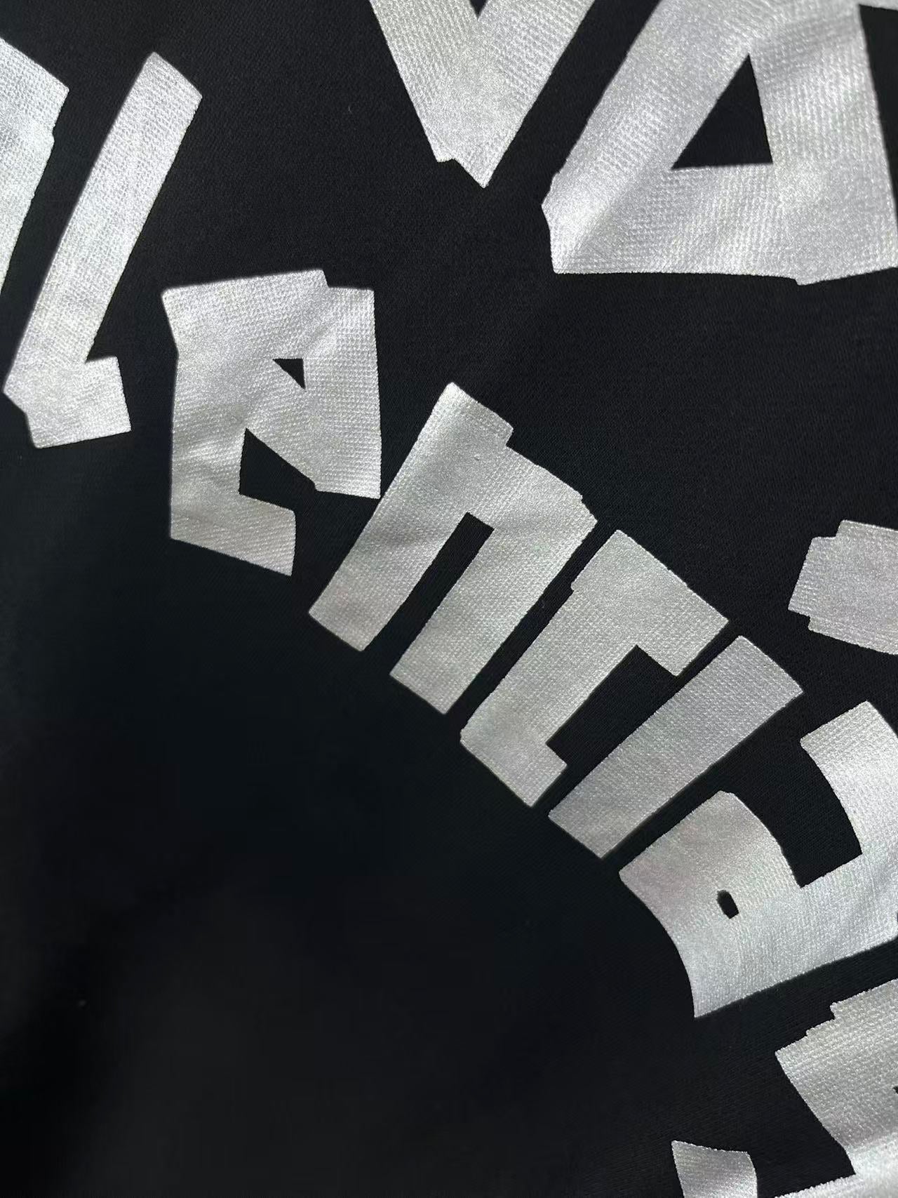 Close-up of angled white graphic lettering on dark hoodie