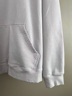 White hoodie pocket and hem close-up with stitched seams and ribbed cuffs