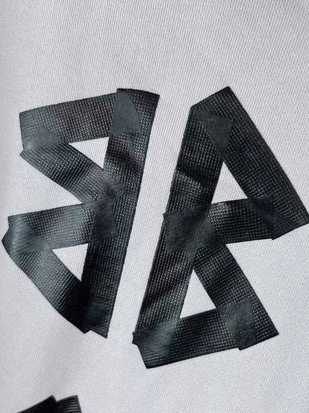 White hoodie chest close-up with oversized black BALENCIAGA letters
