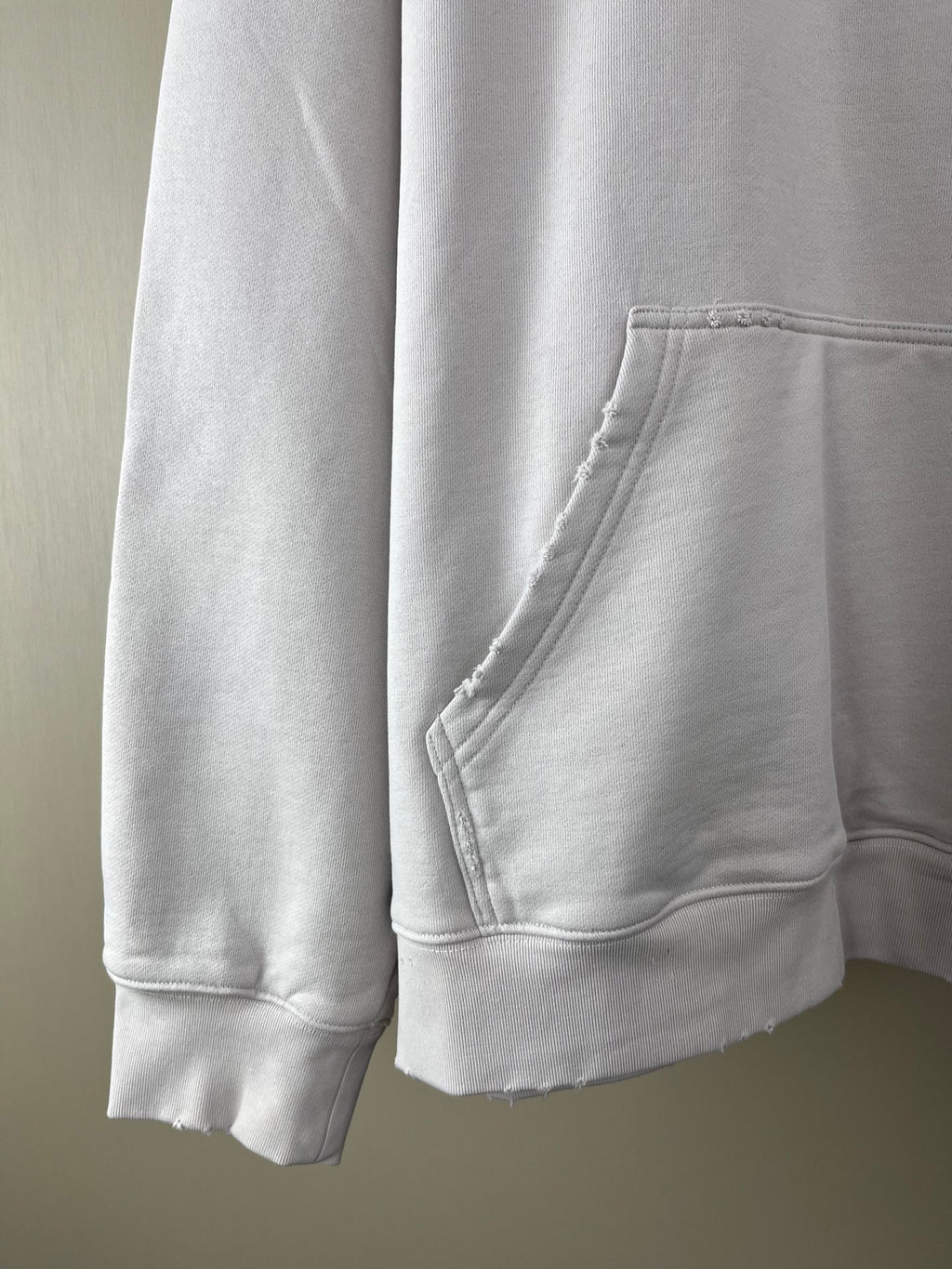 White hoodie side view with kangaroo pocket and ribbed sleeve cuffs