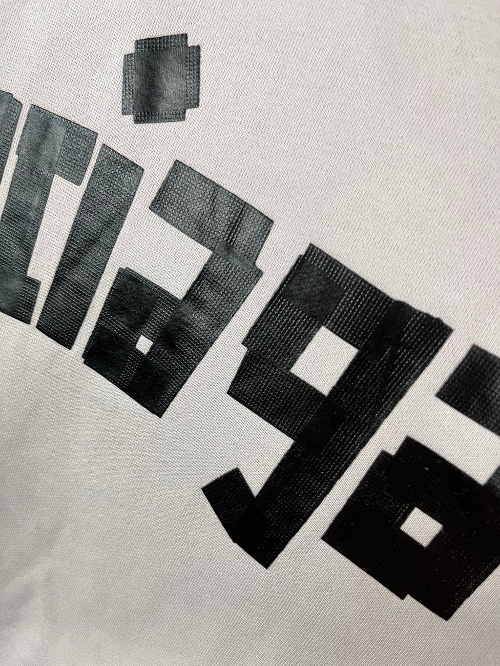 White hoodie chest close-up showing stacked black BALENCIAGA text