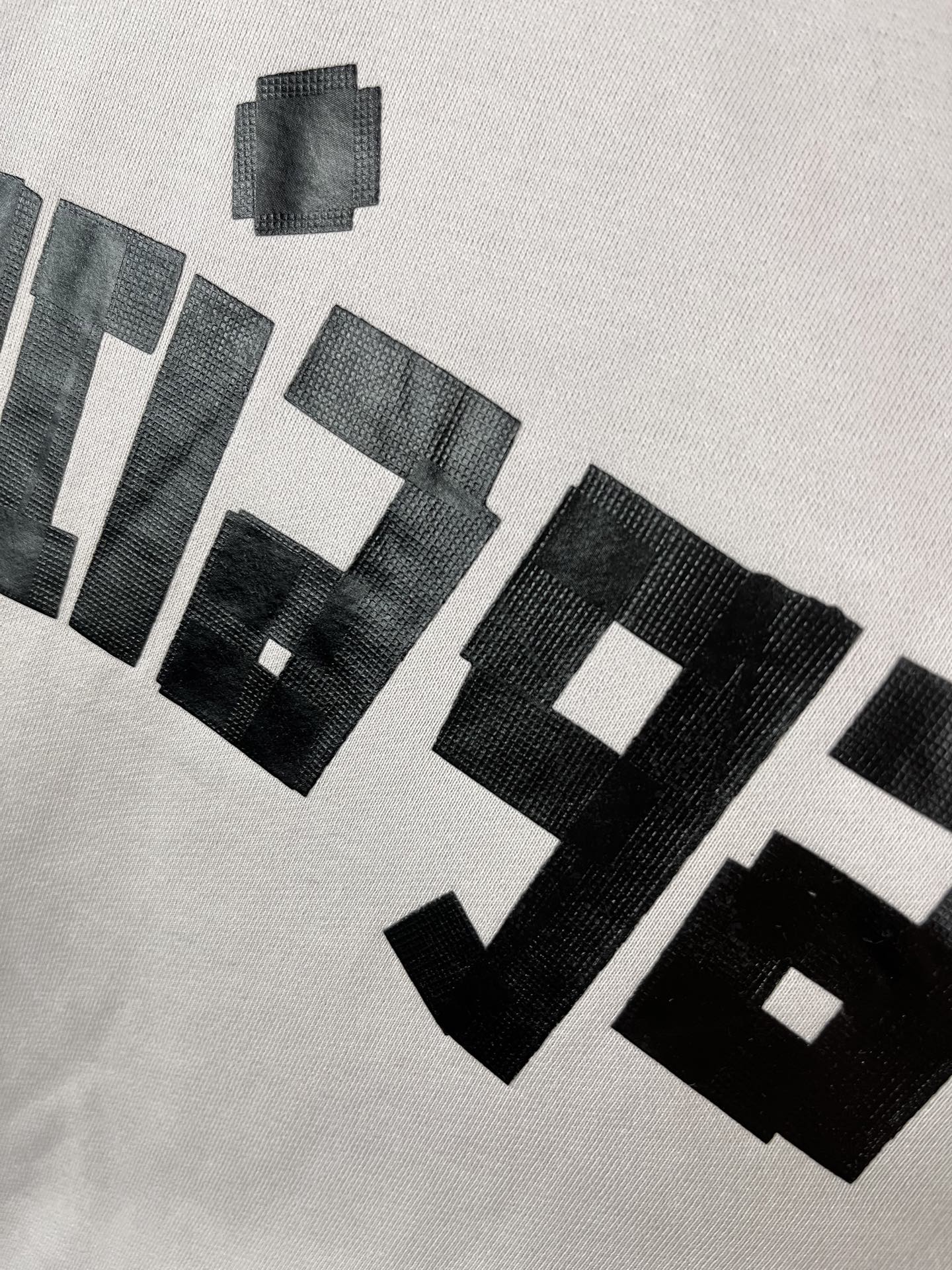 White hoodie chest close-up showing stacked black BALENCIAGA text