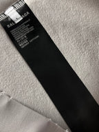 Black size tag inside hoodie with BALENCIAGA text on white fabric