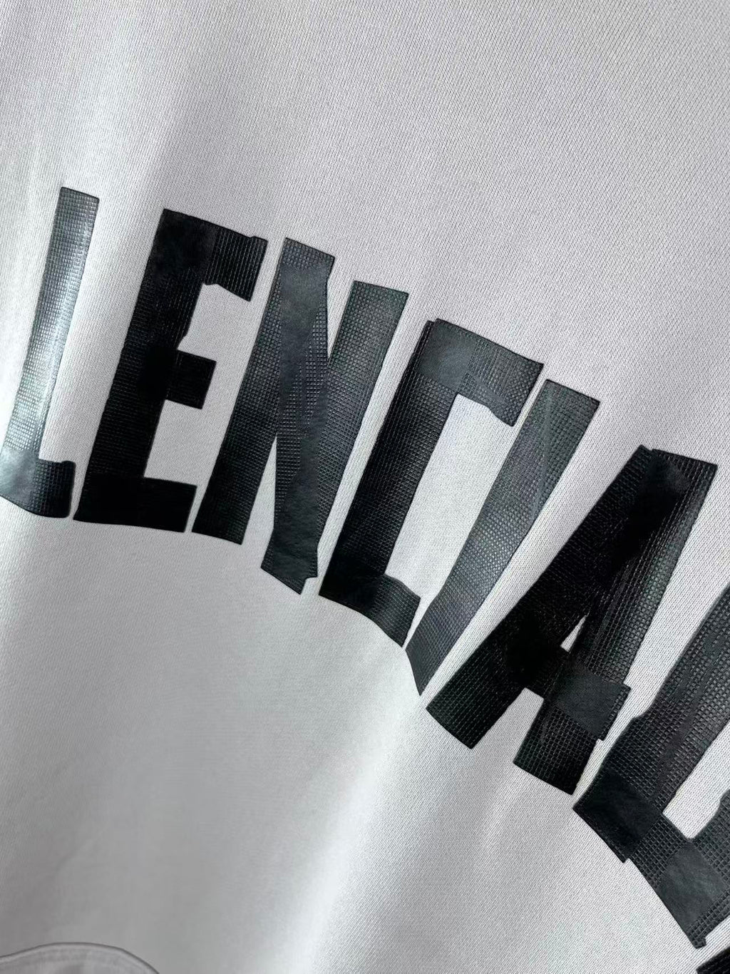 White hoodie close-up showing large black BALENCIAGA lettering
