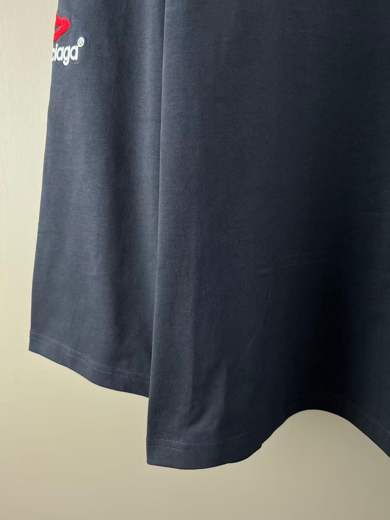 Navy long-sleeve T-shirt side view with logo print and curved bottom hem