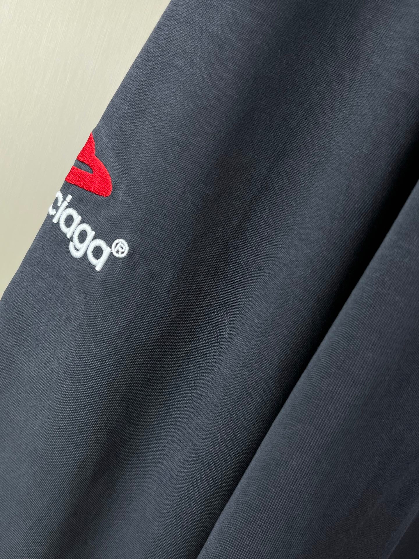 Navy long-sleeve T-shirt sleeve with small red logo and white balenciaga text