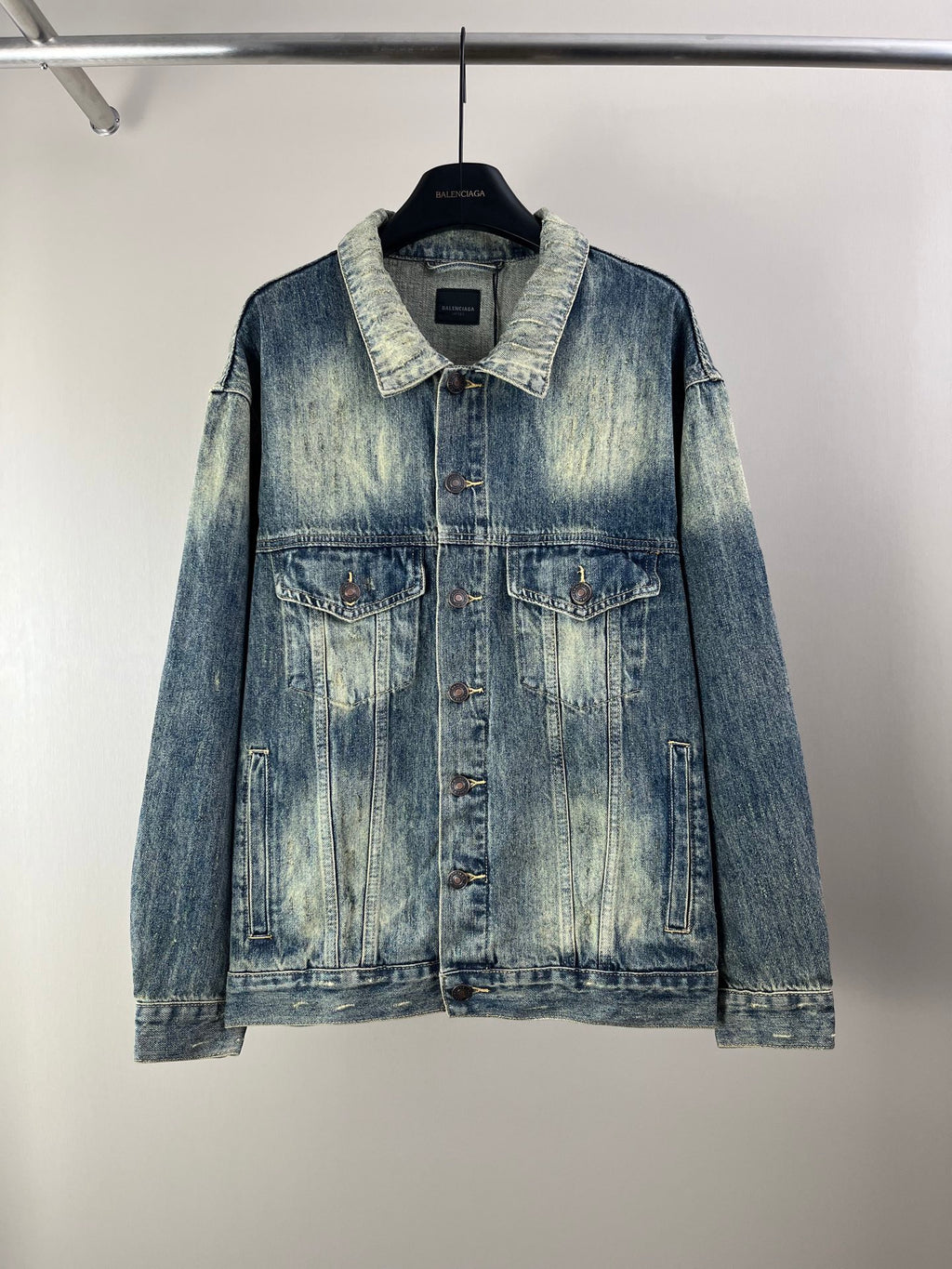 Washed blue denim jacket with button front and two chest flap pockets