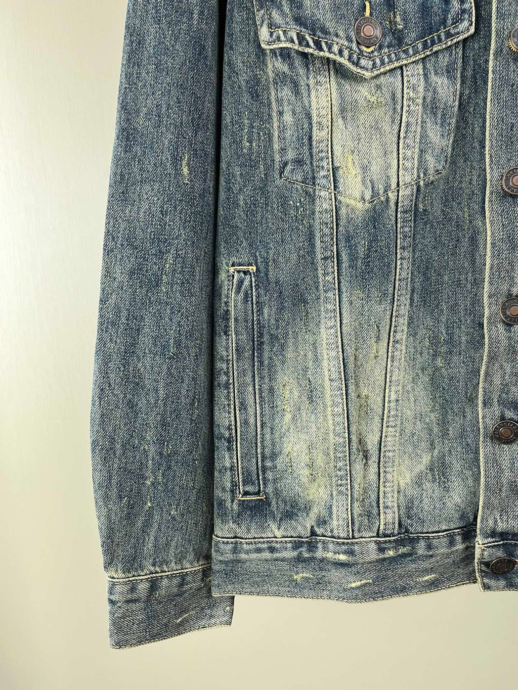 Washed blue denim jacket lower front with vertical flap pocket